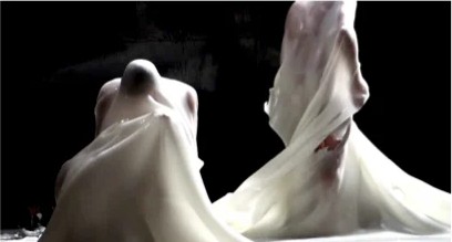 Spectacle de danse : deux silhouettes drapées de blanc sur scène