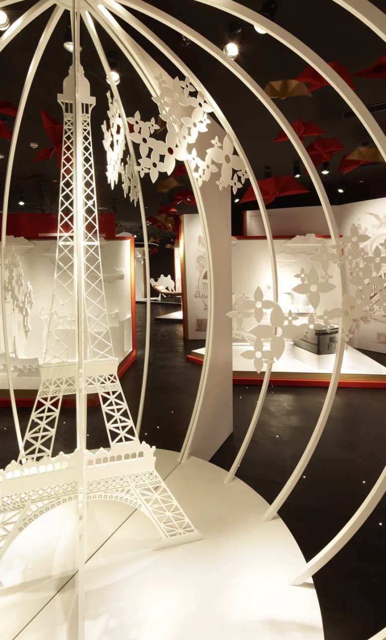 Scénographie d'exposition patrimoniale : sculpture de papier découpé sous une résille blanche