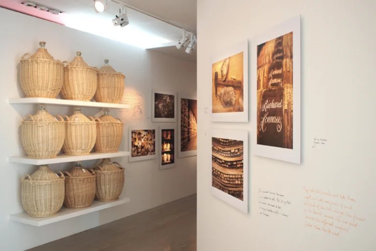 Exposition patrimoniale d'une maison de spiritueux : paniers d'osier et photographies encadrées