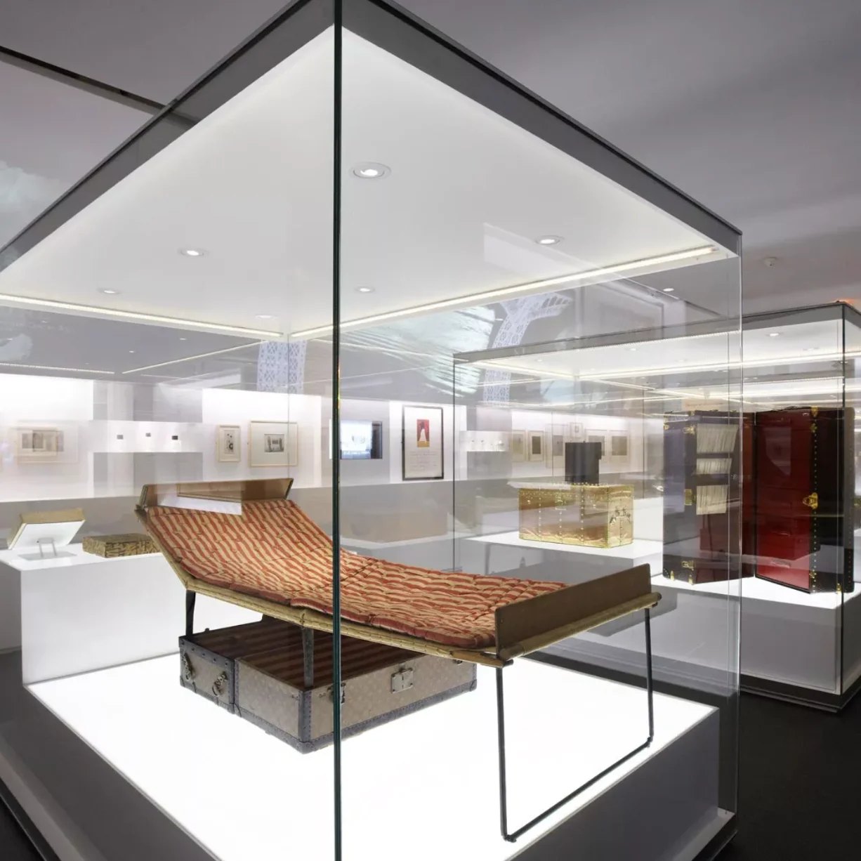 Vitrine muséale d'une maison de luxe présentant une malle historique